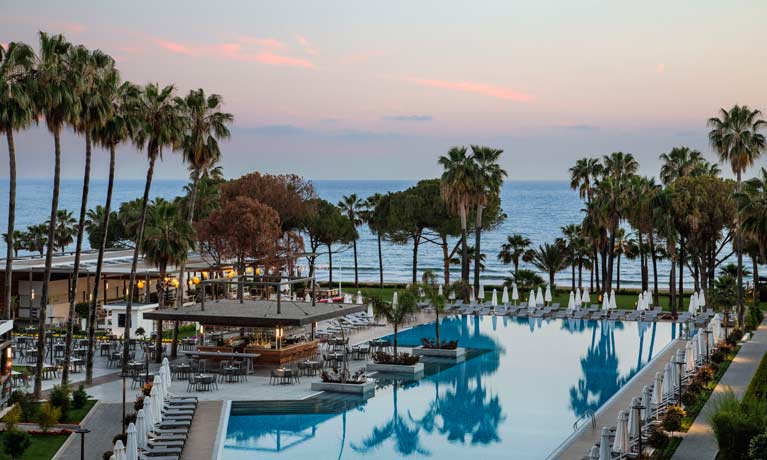 One of the main outdoor swimming pools with its Pool Bar and the sea in the background