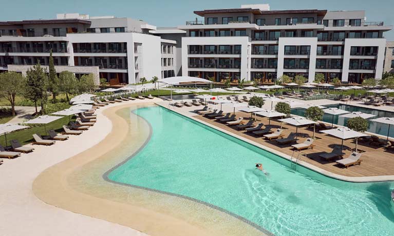 A guest enjoys a quiet swim in the turquoise waters of one of the Anda Barut's main swimming pools