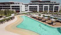 A guest enjoys a quiet swim in the turquoise waters of one of the Anda Barut's main swimming pools