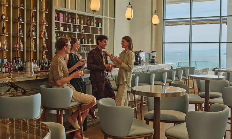 A small group of friends enjoy an evening drink at the lobby bar on their holiday at Anda Barut hotel