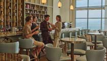 A small group of friends enjoy an evening drink at the lobby bar on their holiday at Anda Barut hotel