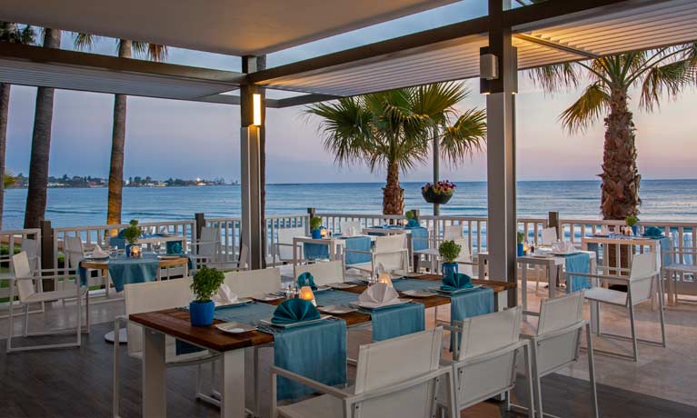 A Barut Collection restaurant at sunset where guests can dine with beautiful views over the clear blue sea