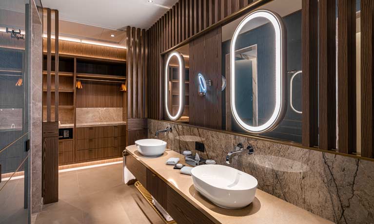 A well equipped and luxurious bathroom at one of the villas with a walk in wardrobe behind
