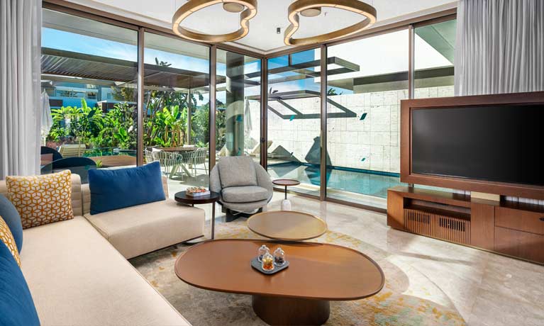 A bright and homely living area in one of the villas with a private swimming pool outside of the large windows