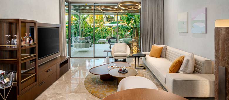 The living room / lounge area in the One Bedroom Villa, with the outside area visible through the sliding full heaight glass doors