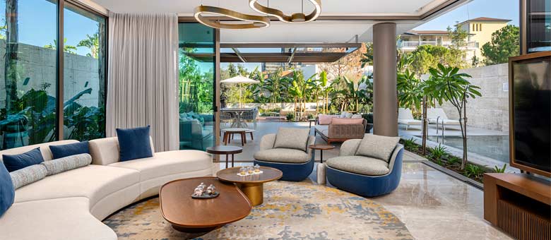 The lounge area of the Three Bedroom Villa is bright and inviting with the private swimming pool visible in the garden outside