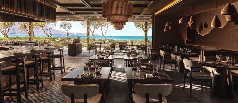 The tables are set at Anaya Restaurant ready for dinner service, with views across the sea visible in the background.