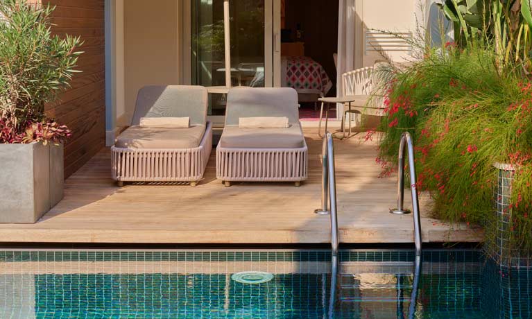 A swim-up room, with its outside terrace featuring a pair of sun loungers and direxct access to the adjacent swimming pool