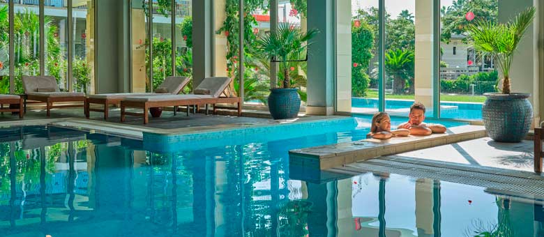 A couple relax in the warm water of the indoor swimming pool at Lara Barut Collection which features a wide range of facilities for guests convenience and relaxation.