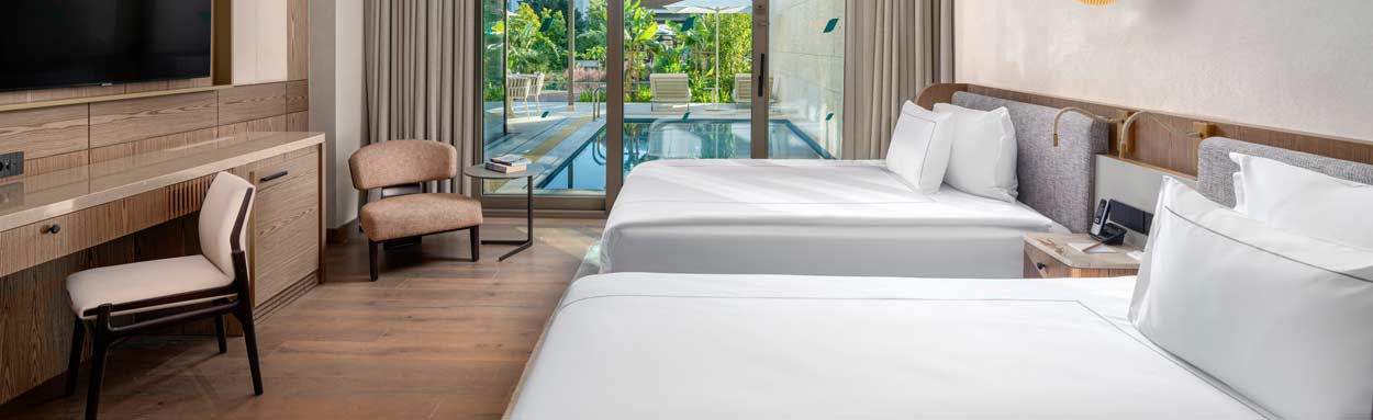 A private swimming pool can be seen outside the patio doors of a comfortable bedroom
