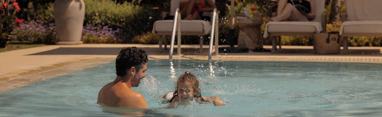 A father and daughter play happily in their private pool at Ikos Andalusia in the 4 bedroom family villa