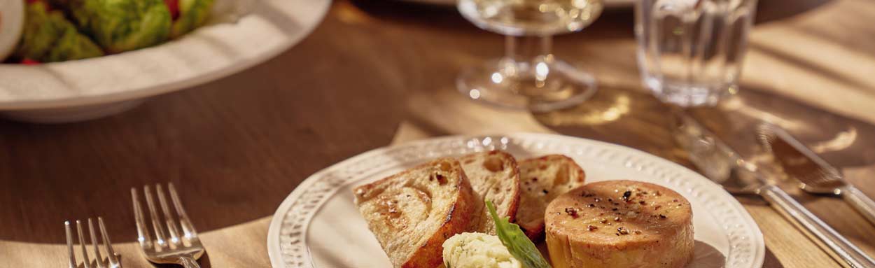 An example of fine dining at Ikos Kissamos, a table is laid out with plates of food and glasses of wine.