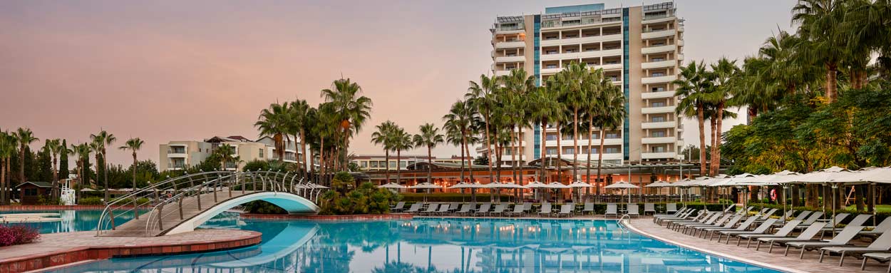 The large outdoor swimming pool at Lara Barut Collection Hotel as the sun goes down